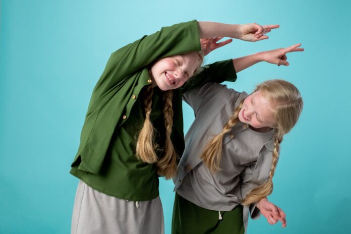 Two girls with long blonde plaits playing together